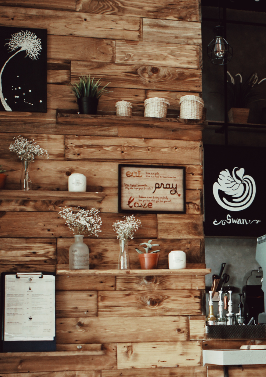 Wooden cafe wall with shelves and a sign